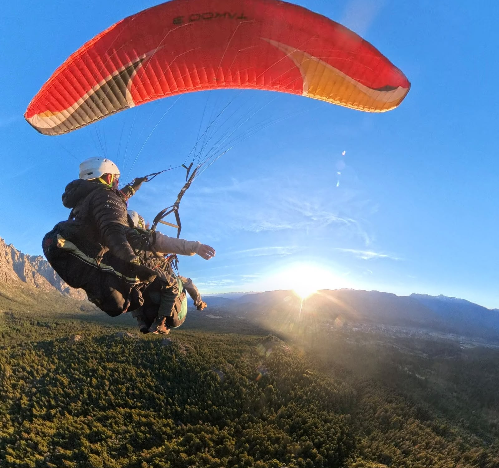 Parapente biplaza sobre montañas de la Patagonia al atardecer